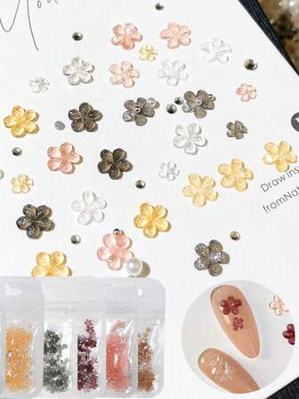 一袋冰晶透明闪亮美甲配件，包含五瓣花瓣、小钢珠和珍珠装饰。DIY美甲装饰材料，适合家庭美甲和专业美甲。