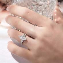 Chiếc nhẫn bạc 925 thời trang này sở hữu thiết kế độc đáo với viên đá Moissanite hình bầu dục 3 carat. Nó kết hợp các yếu tố sành điệu, tiên phong, cổ điển, thanh lịch và đa năng, phù hợp cho cả nam và nữ, và cũng có thể được đeo như nhẫn cưới. - Bạc - Xem 4