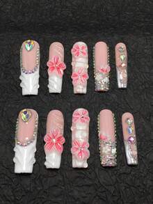 这款10片装手工棺材形美甲贴片套装采用粉色和白色配色，点缀以亮片和水钻，展现出典型的日韩美甲甜美风格。3D立体花朵细节：采用透明/粉色渐变3D雕刻工艺，花瓣纹理细腻，中心镶嵌闪亮水钻。 - 彩色 - 查看 2