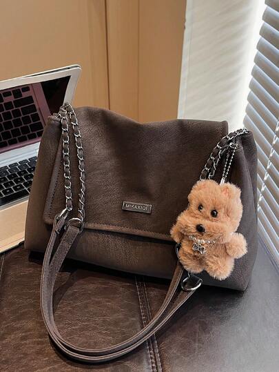 1个咖啡色哑光PU布单肩包，配金属链条装饰和毛绒小狗挂件，可手提或肩背，翻盖设计，甜美可爱风格，适合通勤、购物、春秋季节使用。