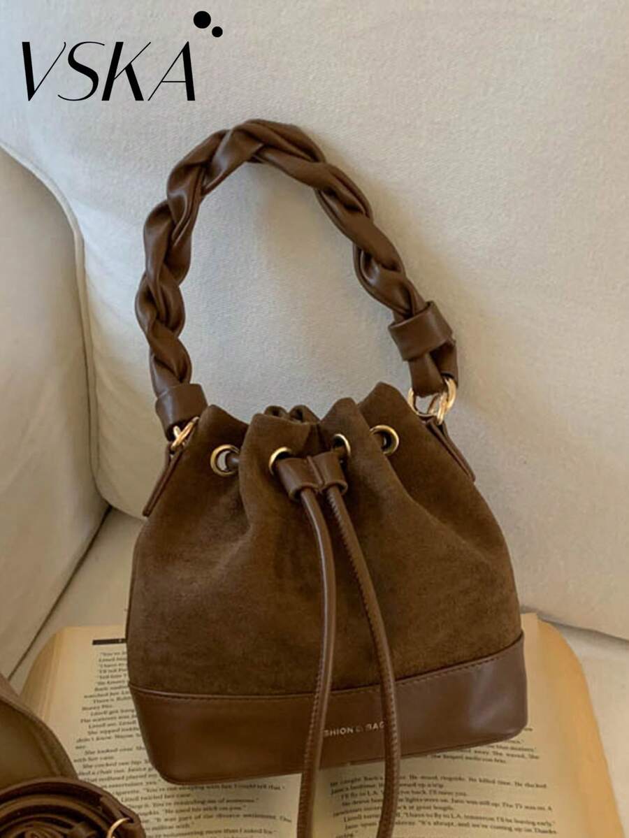 现代宣言抽绳水桶包 | 哑光棕色 * 编织手柄 展现都市复古美学 多功能收纳，诠释质感与实用性的完美平衡理念 深棕色哑光皮革包身，呈现流畅的哑光质感