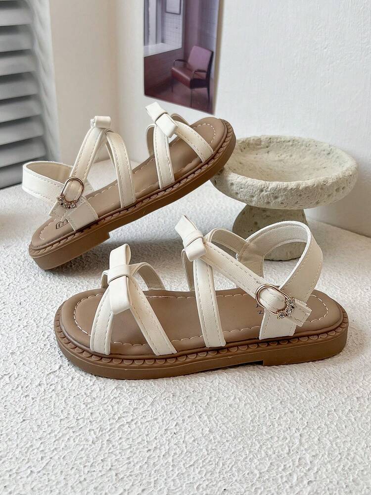 Un par de nuevas sandalias para niños con diseños de lazos y correas y diseños de hebillas metálicas que añaden un toque de refinamiento. Son elegantes y lindas, adecuadas para escenarios diarios y festivos de los niños, e ideales para niños de 3 a 12 años. - Beis - Añade 9