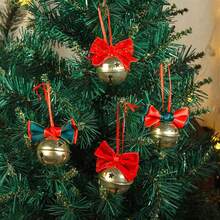 Enfeite de Natal para pendurar, com laço e sinos, feito de tecido e metal, ideal para decorar a árvore ou para festas em casa.