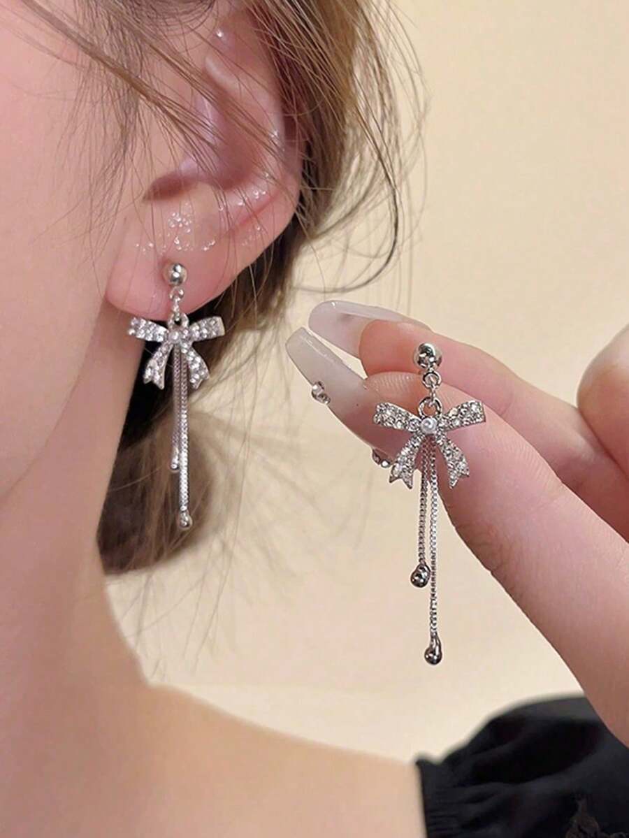 一对简约优雅的镶钻蝴蝶结流苏仿珍珠耳环，奢华别致的设计，适合女性日常和节日佩戴。