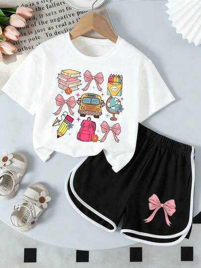 Bộ đồ thường ngày cho bé gái gồm áo thun ngắn tay cổ tròn in hình nơ và sách, gồm áo và quần short.