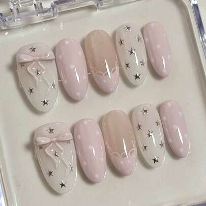 10片柔粉色杏仁形美甲贴纸套装，饰以甜美的波点、蕾丝边、星星和蝴蝶结，打造可爱浪漫的风格。这款全甲可卸美甲贴纸套装适合上班族、学生、派对女孩以及所有季节的美甲爱好者。套装包含1瓶凝胶胶水和1个指甲锉。按压式美甲贴纸。