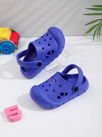 Nya enkla enfärgade barntofflor med hål och platt botten, bekväma för hemma och utomhus, moderiktiga och söta för utomhusbruk