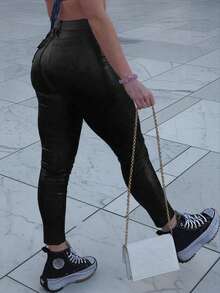 Pantalones pitillo de cintura media de cuero sintético para mujer con bolsillos en diagonal, una elección perfecta para los atuendos navideños.