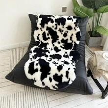 1件仿毛皮米色不对称造型沙发垫，可用作床边垫、躺椅垫。毛绒柔软，高密度聚酯纤维填充。适用于客厅沙发、床边等多种场所。