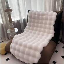 1件仿毛皮米色不对称造型沙发垫，可用作床边垫、躺椅垫。毛绒柔软，高密度聚酯纤维填充。适用于客厅沙发、床边等多种场所。