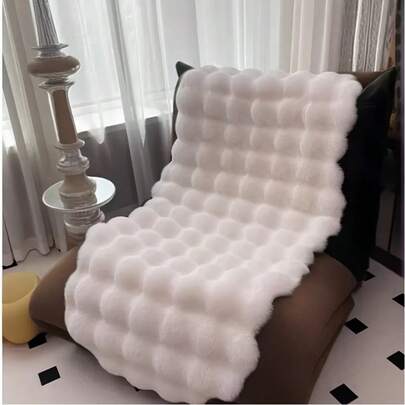 1件仿毛皮米色不对称造型沙发垫，可用作床边垫、躺椅垫。毛绒柔软，高密度聚酯纤维填充。适用于客厅沙发、床边等多种场所。