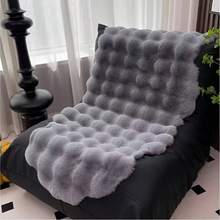 1件仿毛皮米色不对称造型沙发垫，可用作床边垫、躺椅垫。毛绒柔软，高密度聚酯纤维填充。适用于客厅沙发、床边等多种场所。