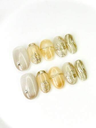 10片中号椭圆形美甲贴片，米色底色，浅金色闪粉，金色闪粉元素，金属边缘设计，3D立体花卉装饰，波浪纹理，点缀小水钻，闪亮夺目。100%纯手工制作，可重复使用，适合女性日常或派对佩戴。
