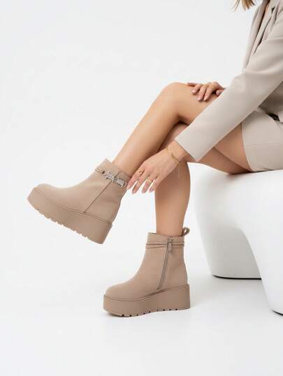 Botki ze sztucznego zamszu ze sprzączką i srebrnymi metalowymi detalami, które dodają odrobinę elegancji.