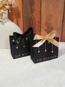 10个优雅的开斋节礼品袋，饰有金色星星吊坠和缎带蝴蝶结，是斋月和开斋节的优质礼品袋，可用于盛装椰枣、糖果、巧克力、小礼物、派对礼品、家庭聚会、节日小吃，也是穆斯林庆祝活动的装饰包装。结实的纸袋非常适合精品礼品、节日餐桌布置和特殊场合的礼品包装。 - 11.5X4.5X10cm - 查看 5