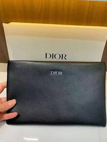 Dior 这款别致的黑色迪奥皮革手拿包饰有品牌标志，尽显奢华美感。无论是出席时尚晚宴还是日常使用，它都是必备单品，完美搭配前卫或优雅的服饰。对于追求高端设计的包袋爱好者来说，这是一款不可错过的精致之作。 - 黑色 - 查看 1