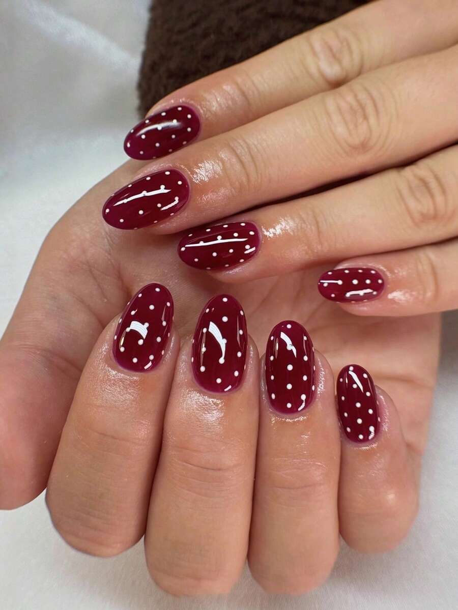 24片椭圆形美甲贴片套装，简约酒红色波点格纹设计，采用欧洲进口透明亚克力材质。是理想的礼物之选，也适合约会、日常佩戴以及其他女性场合。