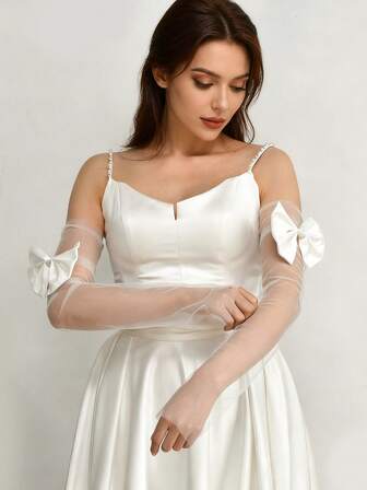 Un par de mangas largas sin dedos para novia, adornadas con lazos, lindas y elegantes, perfectas para combinar con el vestido de novia de una mujer.