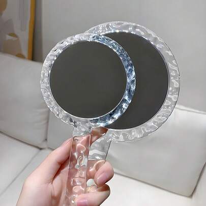 这款水波纹透明手持化妆镜采用水波纹纹理和透明材质设计，便携易用，且结构防碎。它有圆形和方形两种款式，配备高清双面镜，非常适合桌面化妆、浴室剃须和外出补妆，男女皆宜。