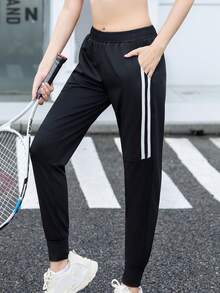 Calça de corrida feminina de cintura alta, com bolsos inclinados, modelo minimalista de cor sólida e corte afunilado, com listras pretas e brancas e cintura elástica. - Preto e Branco - Ver 1