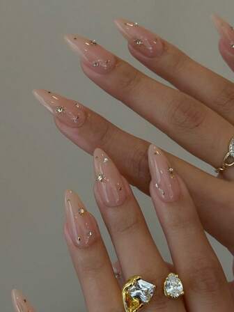 10片手工制作的杏仁形金色星芒可卸式美甲贴片，饰以手工镶嵌的白色水钻，优雅浪漫又不失简约，散发着高端性感和低调奢华的气息。采用Y2K美学设计，非常适合日常佩戴、约会、音乐会以及商务休闲/商务场合——是送给女性和女孩的绝佳礼物。