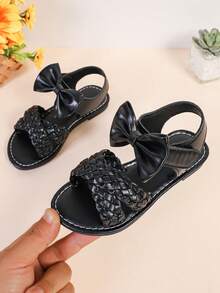 1 par de sandalias planas de color negro para niñas y niños de talla grande, de 3 a 15 años, con decoración de lazo grande tejido de unicolor, cierre con correa, punta redonda y abierta, sandalias romanas de moda y lindas, adecuadas para uso casual, fiesta, viaje, primavera/verano 2025