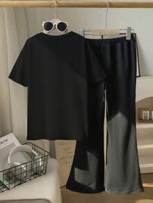 这款斋月主题休闲套装专为年轻女孩设计，饰有新月女孩图案。套装包含一件短袖圆领T恤和一条中腰喇叭裤，非常适合夏季穿着。 - 黑色 - 查看 3
