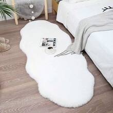 1件仿毛皮米色不对称造型沙发垫，可用作床边垫、躺椅垫。毛绒柔软，高密度聚酯纤维填充。适用于客厅沙发、床边等多种场所。