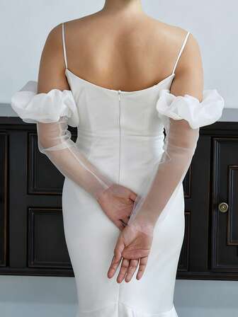 Un par de mangas de gasa blanca suave y ligera, adornadas con flores blancas en los puños. Un diseño francés sencillo, perfecto para combinar con un vestido de novia.