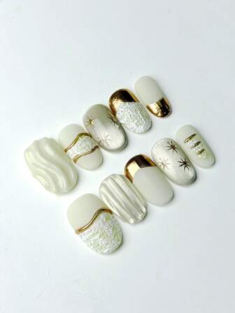 10 piezas de uñas postizas ovaladas medianas con base blanca crema, elegante diseño de bordes dorados, decoración con patrón de estrellas, elementos de textura 3D (onda/raya) y diseño decorativo texturizado brillante 100% hecho a mano. Suministros de uñas reutilizables para uso diario o fiesta de mujeres.
