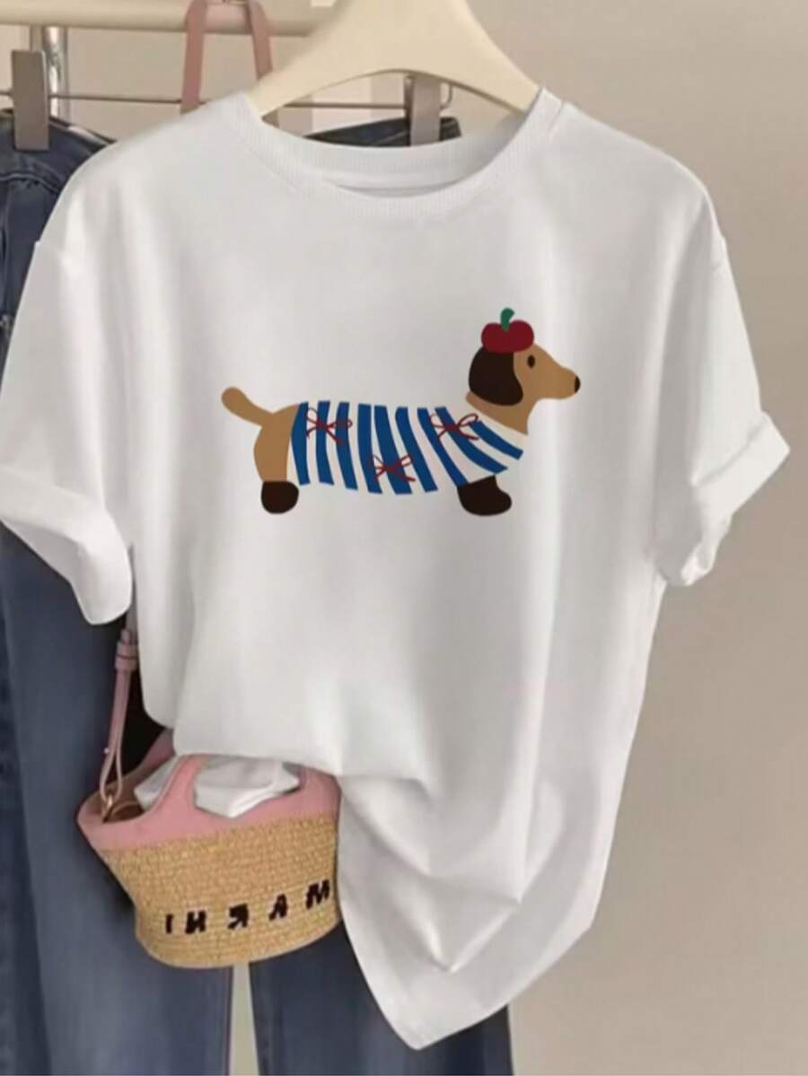 Women's Stylish T-Shirt With A Charming Dachshund Puppy Wearing Blue Striped Clothes In An Exclusive Print Full Of Personality. Ideal For Women Who Love A Delicate, Creative, And Fun Look. A Comfortable And Versatile Piece, Perfect For Creating Modern And Light Casual Looks, Betting On Original Style And A Cute Touch That Makes Any Outfit More Cheerful And Charming. For Everyday Wear, Outings, And Special Occasions. - 白色 - 查看 1