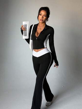 Conjunto deportivo casual de 2 piezas de punto con pantalones acampanados estilizantes con cremallera, puños con agujero para el pulgar, cuello mao y mangas largas en color negro y blanco con efecto de empalme