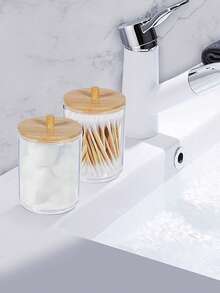 现代圆形棉签收纳盒，亚克力材质，非常适合浴室梳妆台收纳。适用于棉签、化妆球、棉片、化妆海绵、浴盐等。- 4个装 - 透明，带竹制盖子。 - 彩色 - 查看 7