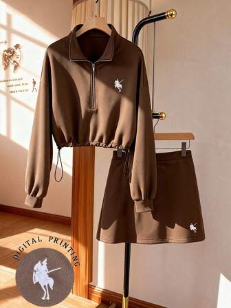 女士休闲亨利领刺绣拉链露脐上衣和半身裙两件套，采用中等弹力面料，适合日常穿着