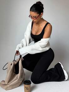 Women's Minimalist Black Cross-Back Yoga Jumpsuit With Flared Legs. Perfect For Indoor And Outdoor Practice, Designed For A Confident And Elegant Stride.