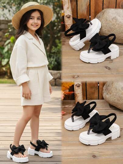 1双黑色坡跟凉鞋，大童款，柔软面料，蝴蝶结装饰，弹性后跟带，圆头设计，3厘米厚防滑鞋底，可爱时尚，适合海滩/休闲/上学/度假穿着，春夏皆宜。