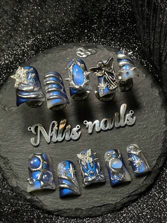 Vive un romance con la hecha a mano de 10 piezas de uñas postizas cortas y divertidas tipo pato con cobertura total, en blanco transparente y azul tie-dye, con un patrón geométrico metálico líquido pintado a mano, combinado con estrellas 3D, remaches y patrones de estallido de estrellas para una cobertura total. Perfectas para uso diario, fiestas, ceremonias y uso cotidiano. El kit de herramientas incluido es un gran regalo para mujeres.