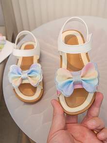 一双儿童/女孩蝴蝶结凉鞋，色彩缤纷的蝴蝶结，白色皮革，柔软舒适，轻便透气，是夏季的理想之选！这款可爱的露趾凉鞋配有可调节的踝带，确保穿着稳固。为任何装扮增添一抹亮丽色彩。透气内衬让小脚丫保持干爽舒适。