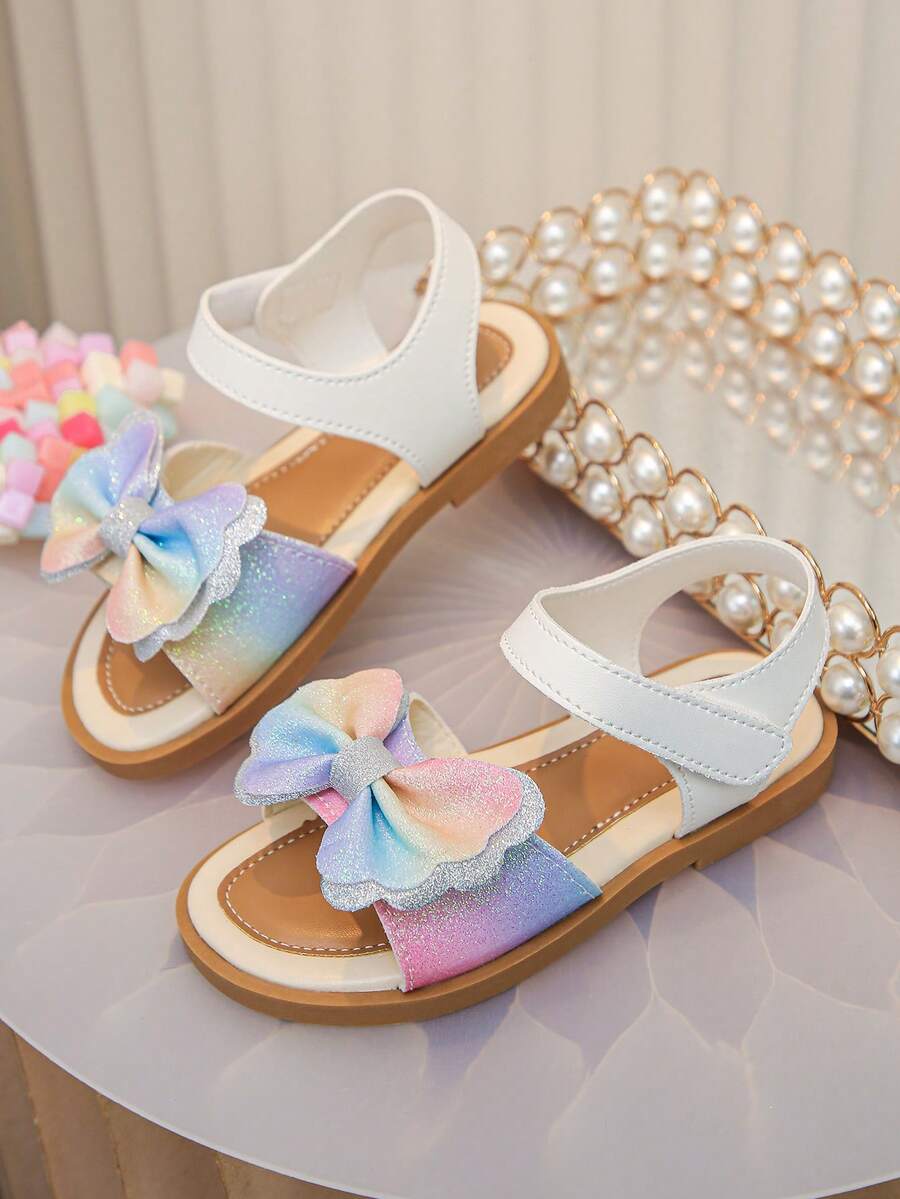A Pair Of Children's Bow-Shaped Flat Sandals. Made Of Soft Napa PU Leather, With A Hook And Loop Design For Easy On And Off.