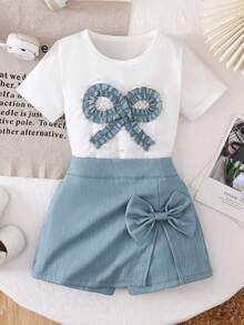 Bộ đồ hè 2 món cho bé gái 4-7 tuổi: áo thun trắng và quần váy denim xanh, trang trí nơ xinh xắn đính đá, phong cách châu Âu ngọt ngào, chất liệu co giãn thoải mái, bộ sưu tập mới năm 2026. - Màu xanh lam - Xem 2