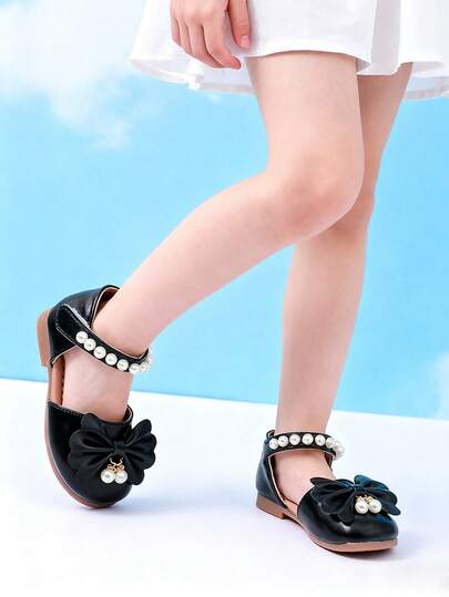 1双儿童平底凉鞋，镂空绑带设计，方便穿脱，饰有蝴蝶结和仿珍珠，柔软舒适的橡胶防滑鞋底，优雅的女童凉鞋，适合上学、演出和日常穿着。