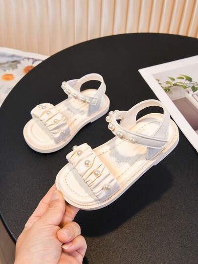 1双女童珍珠装饰凉鞋，儿童时尚凉鞋，褶皱仿皮鞋面+圆形珍珠，散发柔美公主气息！柔软鞋底，防滑耐穿，适合跑步跳跃，可搭配连衣裙和裤子，舒适甜美，是夏季外出的理想之选。