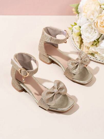 1 Pair Of Girls' Golden Bow Decorated Sandals, With An Artificial PU Leather Upper And A Shimmering Pink Bow And Ankle Strap That Fits The Feet. The Square Toe Low Top Style Is Comfortable With A Low Heel, Shining With A Sweet Breeze, Suitable For Holiday Celebrations And Flower Girl Styling Occasions.