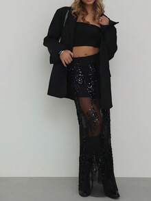 Saia preta de lantejoulas, elegante e com recortes em tule, ideal para festas e encontros românticos no início da primavera.