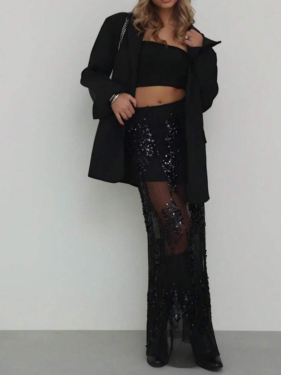 Saia preta de lantejoulas, elegante e com recortes em tule, ideal para festas e encontros românticos no início da primavera.