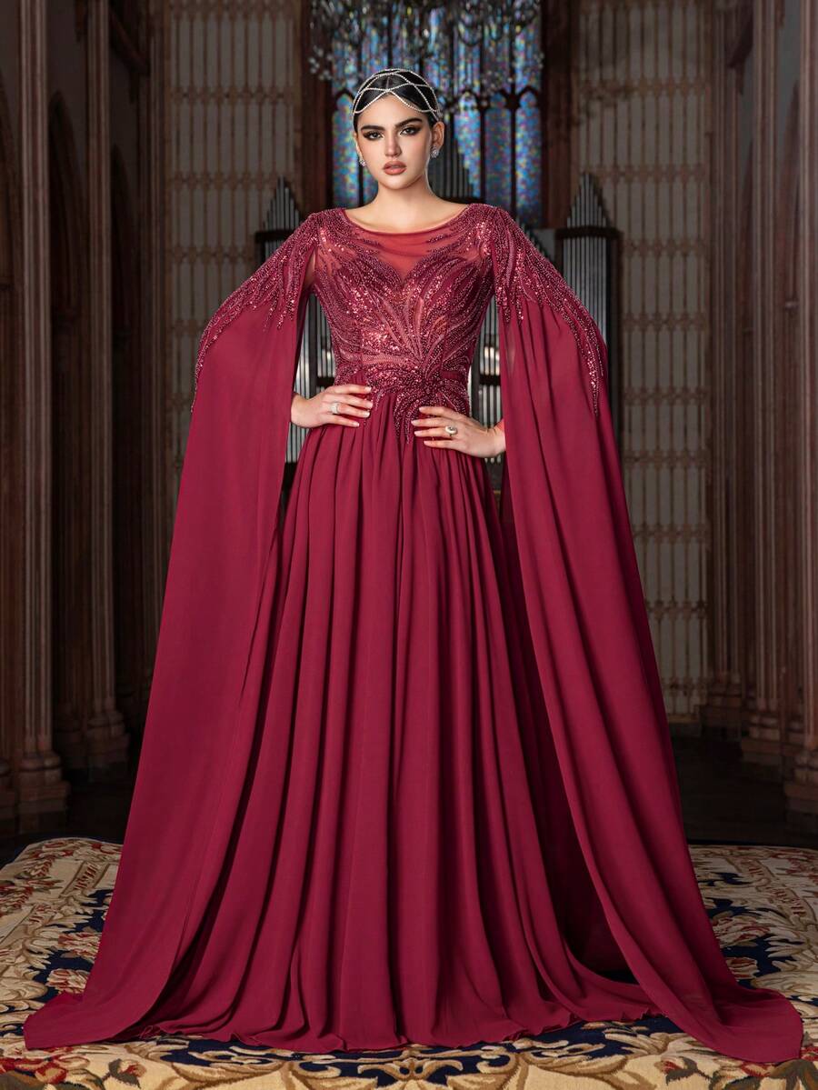 Cette robe en mousseline pour femme présente un col châle drapé et des manches évasées en forme de cloche. Le corsage est orné d'un motif pailleté et perlé radieux, et la jupe évasée jusqu'aux chevilles crée une silhouette fluide et élégante. Cette robe est un choix idéal pour les mariages, les galas de gala, les célébrations culturelles et les événements sur le tapis rouge.