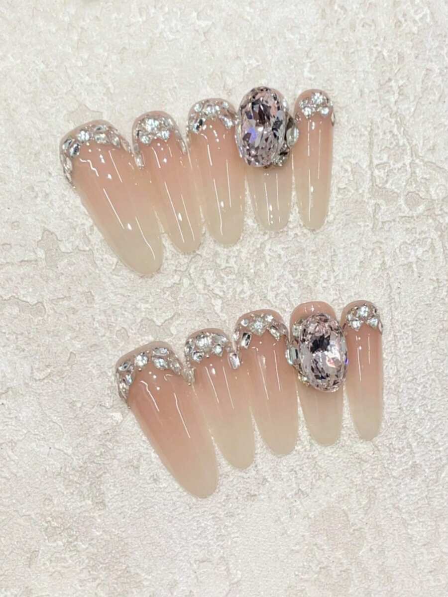 Sanfte Berührung an Ihren Fingerspitzen! Set mit 10 handgefertigten ovalen Sarg-Nägeln mit einem zarten und raffinierten Nude-Farbverlauf für die französische Maniküre, dekoriert mit von Hand aufgetragenen Strass-Steinen und hellrosa K9-Strass. Sanft und elegant, perfekt für Dates, Treffen mit Freunden, den Alltag oder als Geschenk. Wiederverwendbares handgefertigtes Aufklebe-Nagel-Set inklusive Gelee-Kleber und Mini-Nagelfeile. Nagelzubehör handgefertigte Aufklebe-Nägel - Verschiedenfarbig - Übersicht 1