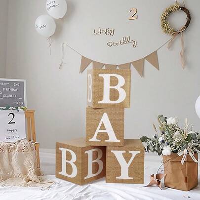 亚麻纹理纸婴儿字母积木盒 - 这款积木盒采用温暖复古的亚麻纹理纸外层，轻巧而坚固，并印有醒目的白色字母“Baby”，适合用作婴儿派对中心装饰品、新生儿摄影背景、婴儿房装饰或宝宝百日庆典餐桌布置。