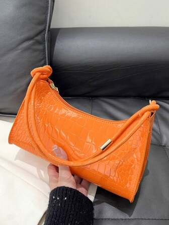 新款时尚简约腋下包，女士鳄鱼纹橙色小众法棍包，新月形单肩包，轻便商务休闲斜挎包，适合女大学生、新人及上班族女性，适用于办公室、大学、工作、商务、通勤、户外、旅行、外出等各种场合。
