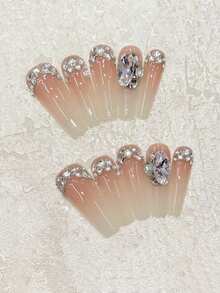 Sanfte Berührung an Ihren Fingerspitzen! Set mit 10 handgefertigten ovalen Sarg-Nägeln mit einem zarten und raffinierten Nude-Farbverlauf für die französische Maniküre, dekoriert mit von Hand aufgetragenen Strass-Steinen und hellrosa K9-Strass. Sanft und elegant, perfekt für Dates, Treffen mit Freunden, den Alltag oder als Geschenk. Wiederverwendbares handgefertigtes Aufklebe-Nagel-Set inklusive Gelee-Kleber und Mini-Nagelfeile. Nagelzubehör handgefertigte Aufklebe-Nägel - Verschiedenfarbig - Übersicht 2